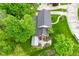 Overhead shot of a red brick house, highlighting its spacious lawn, driveway, and surrounding mature trees at 6567 Kings Ct, Avon, IN 46123