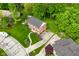 An aerial view of a red brick home with a well-kept lawn, mature trees, and a paved driveway and walkway at 6567 Kings Ct, Avon, IN 46123