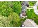 An aerial view featuring a red brick home with well-maintained lawn and surrounded by mature trees at 6567 Kings Ct, Avon, IN 46123