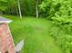 Scenic backyard featuring a well-kept lawn adjacent to the red brick home and surrounding mature trees at 6567 Kings Ct, Avon, IN 46123