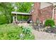 Landscaped backyard featuring a covered deck, garden decor, and mulched flower beds blending nature and comfort at 6567 Kings Ct, Avon, IN 46123