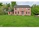 Traditional two-story brick home with a lush green lawn, mature trees, and a welcoming front facade at 6567 Kings Ct, Avon, IN 46123