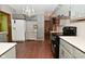 Well-lit kitchen with grey cabinetry, black appliances, and hardwood floors at 6567 Kings Ct, Avon, IN 46123