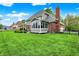 Large backyard view of the house, the screened-in porch, brick chimney and a green lawn at 7248 River Birch Ln, Indianapolis, IN 46236