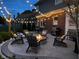 Relaxing backyard patio enhanced with a cozy fire pit, comfortable seating and charming string lights at 7248 River Birch Ln, Indianapolis, IN 46236