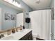 This modern bathroom includes a double sink vanity, framed mirror, and a shower with a patterned curtain at 7248 River Birch Ln, Indianapolis, IN 46236
