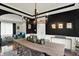 Modern dining room with black accent wall, white wainscoting, and an elegant chandelier at 7248 River Birch Ln, Indianapolis, IN 46236