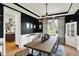 Stylish dining room featuring modern light fixture, black accent wall, and view to the backyard at 7248 River Birch Ln, Indianapolis, IN 46236
