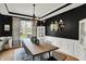 Stylish dining room with black accent wall, modern lighting, and seating for eight at 7248 River Birch Ln, Indianapolis, IN 46236