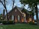 Brick home's exterior at dusk featuring a well-maintained lawn and garden at 7248 River Birch Ln, Indianapolis, IN 46236