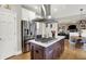 Bright kitchen with stainless steel fridge, island cooktop, and view to living room and breakfast nook at 7248 River Birch Ln, Indianapolis, IN 46236