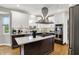 Modern kitchen featuring stainless steel appliances, white cabinets, and a central island with a gas cooktop at 7248 River Birch Ln, Indianapolis, IN 46236