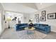 Open concept living room with blue velvet sofa and view of kitchen beyond at 7248 River Birch Ln, Indianapolis, IN 46236