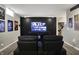Entertaining living room with theater seating, hardwood floors and a large screen television at 7248 River Birch Ln, Indianapolis, IN 46236