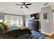 Stylish main bedroom featuring a statement wall, a plush bed, modern furniture, and lots of light from windows at 7248 River Birch Ln, Indianapolis, IN 46236