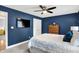 This main bedroom boasts deep blue walls, a ceiling fan, and a flat-screen TV for optimal comfort and entertainment at 7248 River Birch Ln, Indianapolis, IN 46236