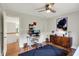 Bright home office featuring hardwood floors, a modern desk setup, and a stylish cabinet with a pop-art accent at 7248 River Birch Ln, Indianapolis, IN 46236