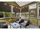 Charming screened-in porch with outdoor seating, string lights, and views of the lush greenery outside at 7248 River Birch Ln, Indianapolis, IN 46236