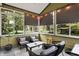 Inviting screened-in porch with comfortable outdoor seating, string lights, and views of the landscaped backyard at 7248 River Birch Ln, Indianapolis, IN 46236