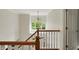 Bright staircase with hardwood railing and view of greenery through transom window and chandelier at 7248 River Birch Ln, Indianapolis, IN 46236