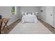 Bright bedroom with white linens, side tables, and a large rug at 8120 E 11Th St, Indianapolis, IN 46219