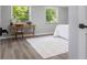 Comfortable bedroom with two windows, wood floors, a desk and a white rug at 8120 E 11Th St, Indianapolis, IN 46219