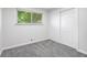 Bedroom features neutral carpet and paint, as well as a window and a closet at 8120 E 11Th St, Indianapolis, IN 46219