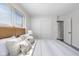 Comfortable bedroom with a window, large closet, bright walls and a bed with striped linen and decorative pillows at 8120 E 11Th St, Indianapolis, IN 46219