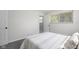 Serene bedroom with clean lines, a comfy bed, and natural light streaming through a window at 8120 E 11Th St, Indianapolis, IN 46219