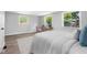 Bright bedroom with white linens, windows and wood floors at 8120 E 11Th St, Indianapolis, IN 46219
