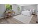 Comfortable bedroom featuring two windows, wood floors, a desk and a white rug at 8120 E 11Th St, Indianapolis, IN 46219