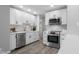 Modern kitchen featuring white cabinets, stainless steel appliances, updated hardware, and hardwood floors at 8120 E 11Th St, Indianapolis, IN 46219