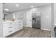 Spacious kitchen featuring white cabinets, stainless steel fridge, island with seating, and hardwood floors at 8120 E 11Th St, Indianapolis, IN 46219
