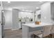Bright kitchen featuring white cabinets, stainless steel appliances, an island with seating, and hardwood floors at 8120 E 11Th St, Indianapolis, IN 46219