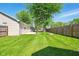 Expansive backyard with green lawn, wooden fence and large shade tree provide ample outdoor space at 813 Stoner Dr, Anderson, IN 46013