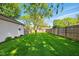 Fenced backyard features a lush lawn with a play structure and mature trees, perfect for Gathering activities at 813 Stoner Dr, Anderson, IN 46013