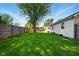 Large backyard with wooden fence and manicured lawn leading toward an outbuilding, offering privacy and utility at 813 Stoner Dr, Anderson, IN 46013
