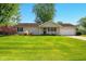 Attractive single-story home featuring a manicured lawn and inviting front entrance with black door and shutters at 813 Stoner Dr, Anderson, IN 46013