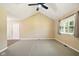 Bright living room features vaulted ceilings, neutral carpet and paint, and natural light from large window at 813 Stoner Dr, Anderson, IN 46013