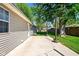 Concrete patio extends from the home, transitioning to a grassy yard with mature trees and privacy fencing at 813 Stoner Dr, Anderson, IN 46013