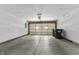 Two car garage interior with a partially opened garage door and refuse receptacles on the side at 8158 S Firefly Dr, Pendleton, IN 46064