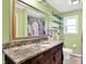 Stylish bathroom with granite countertop, decorative mirror, and a shower at 8230 Linda Leigh Ln, Indianapolis, IN 46217