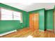 Bedroom with hardwood floors, window, and a closet with wooden doors at 8230 Linda Leigh Ln, Indianapolis, IN 46217