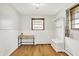 White bedroom with a desk, storage bench, and hardwood flooring at 8230 Linda Leigh Ln, Indianapolis, IN 46217