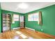 Bright bedroom with hardwood floors, green walls, windows, and built-in storage cabinets at 8230 Linda Leigh Ln, Indianapolis, IN 46217