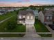 Inviting two-story home with attached two-car garage, water view, and manicured lawn at 8238 Crackling Ln, Indianapolis, IN 46259