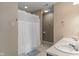 Bathroom with a shower and curtain, double sinks, light brown walls, and an earth-toned floor at 8238 Crackling Ln, Indianapolis, IN 46259