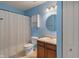 Bathroom with blue walls, a toilet, white shower curtain, and a vanity with a sink and cabinet at 8238 Crackling Ln, Indianapolis, IN 46259