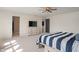 A bright bedroom with a ceiling fan, carpet floors, and a modern white dresser with a flatscreen TV at 8238 Crackling Ln, Indianapolis, IN 46259