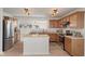 Bright kitchen features wood cabinets, stainless steel appliances, island, and opens to the dining area at 8238 Crackling Ln, Indianapolis, IN 46259